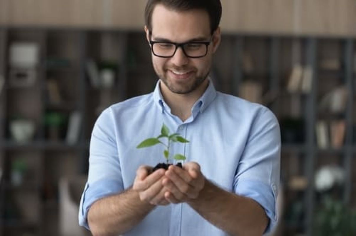 hombre sonriente con planta