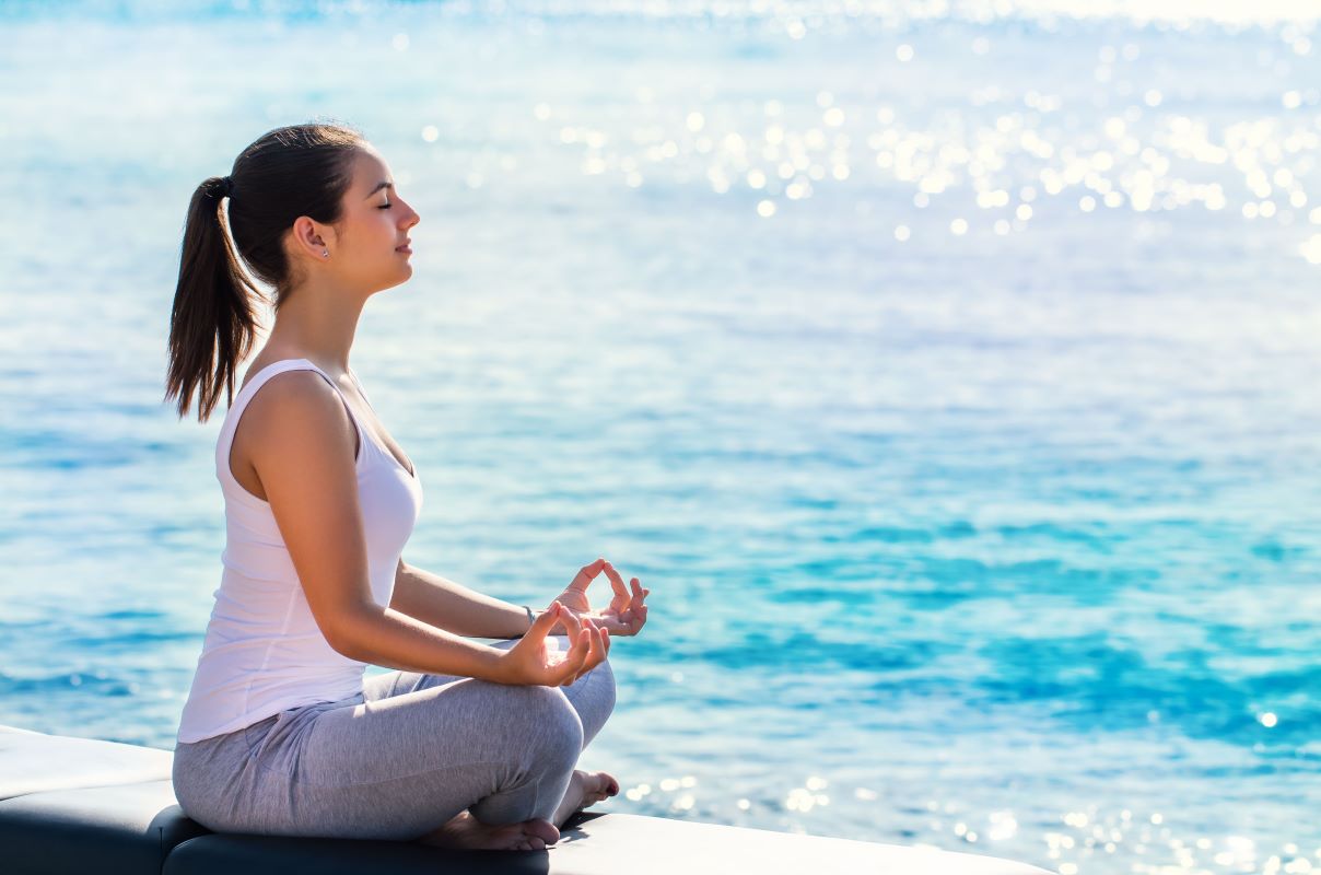 mujer meditando frente al mar